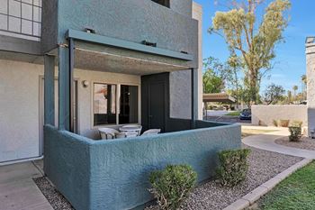 A modern house with a blue exterior and a small garden in front.